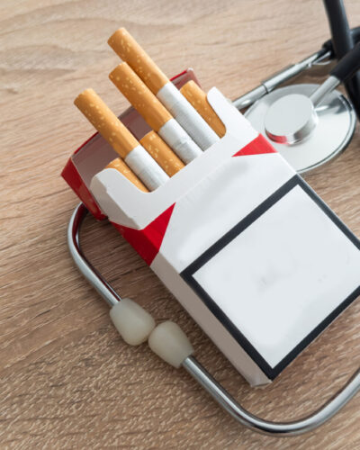 Cigarettes and stethoscope on insurance documents. High quality photo